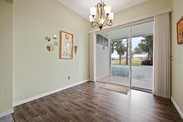 unfurnished dining area featuring lofted ceiling, an inviting chandelier, and dark wood-type flooring