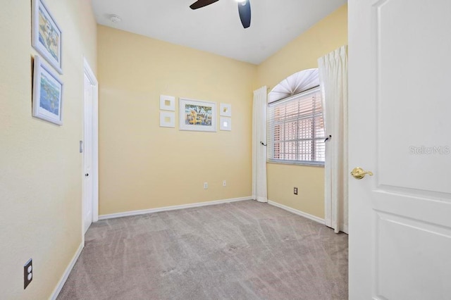 carpeted spare room with ceiling fan