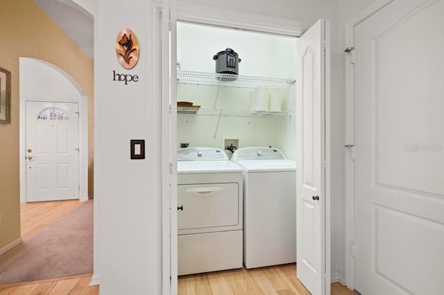 laundry area with washing machine and dryer and light hardwood / wood-style floors