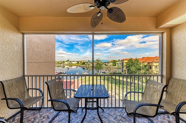 balcony with a water view and ceiling fan