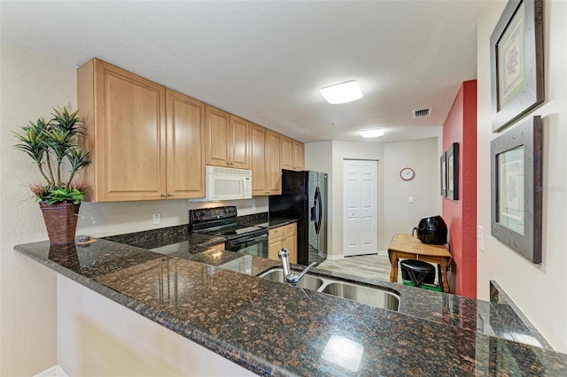 kitchen with sink, dark stone countertops, black appliances, a textured ceiling, and kitchen peninsula