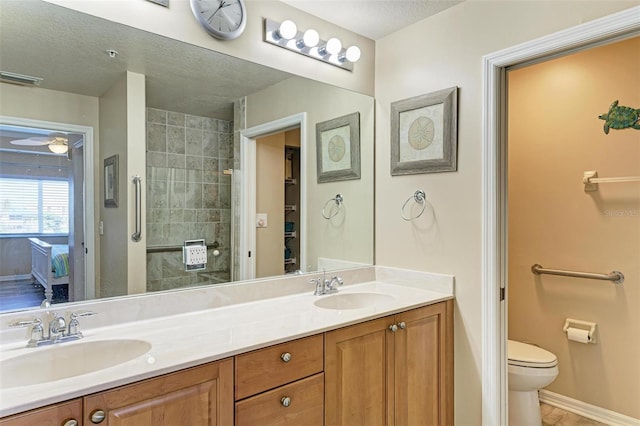 bathroom with vanity, a textured ceiling, and toilet