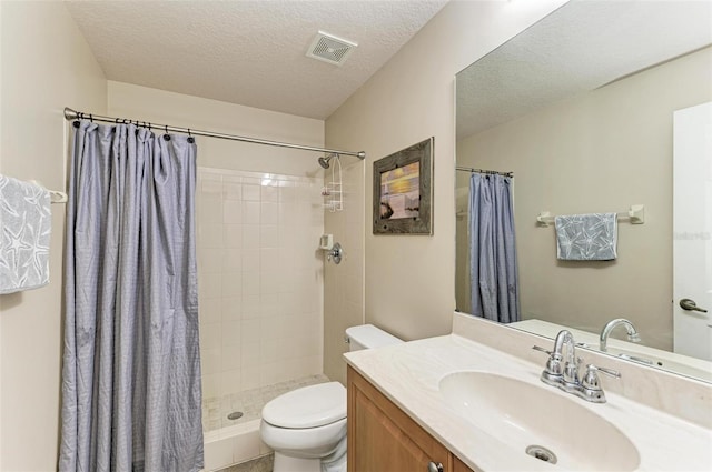 bathroom featuring a shower with curtain, vanity, a textured ceiling, and toilet