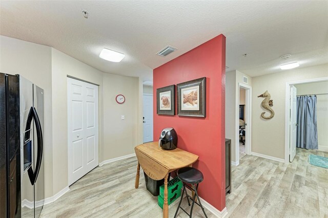 3322 Purple Martin Dr Unit 135, Punta Gorda, FL 33950 - kitchen with light hardwood / wood-style flooring, a textured ceiling, and stainless steel refrigerator with ice dispenser