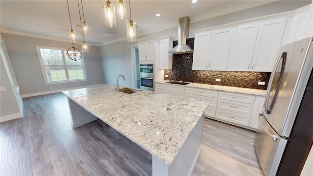 kitchen with stainless steel appliances, white cabinetry, a large island, and decorative light fixtures