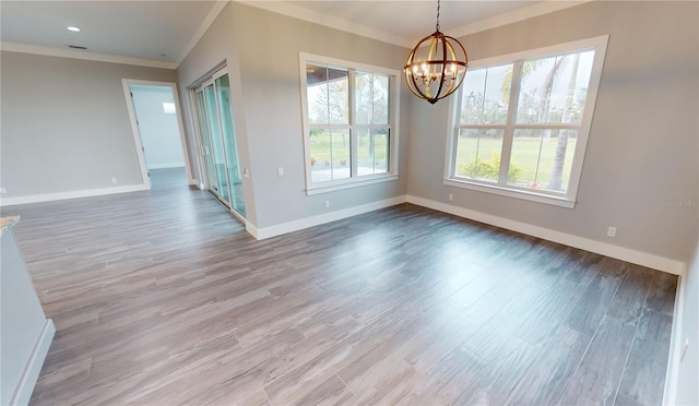 unfurnished dining area featuring an inviting chandelier, ornamental molding, and hardwood / wood-style flooring