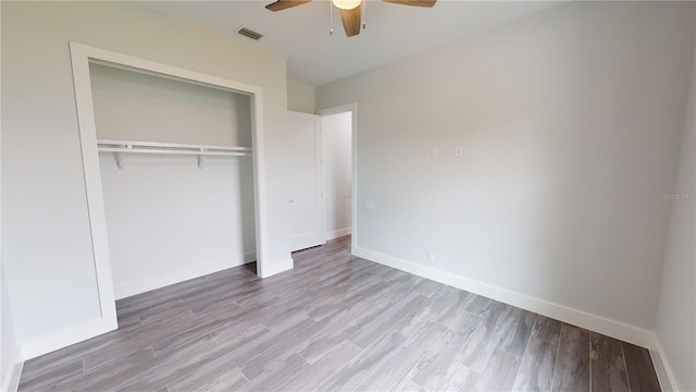 unfurnished bedroom with light wood-type flooring, ceiling fan, and a closet