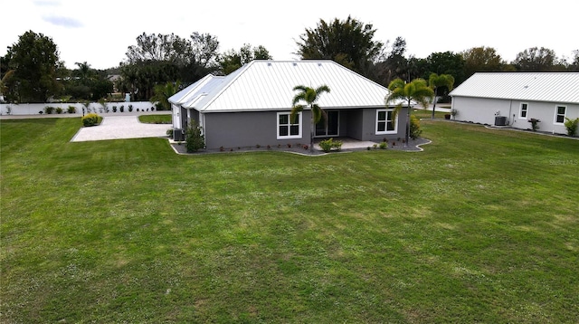 back of house with cooling unit and a yard