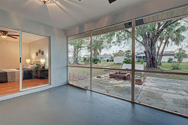 unfurnished sunroom featuring ceiling fan