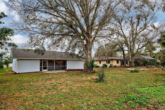 rear view of property with a sunroom and a yard