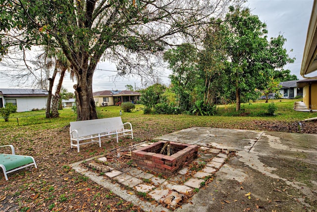 view of yard featuring an outdoor fire pit and a patio