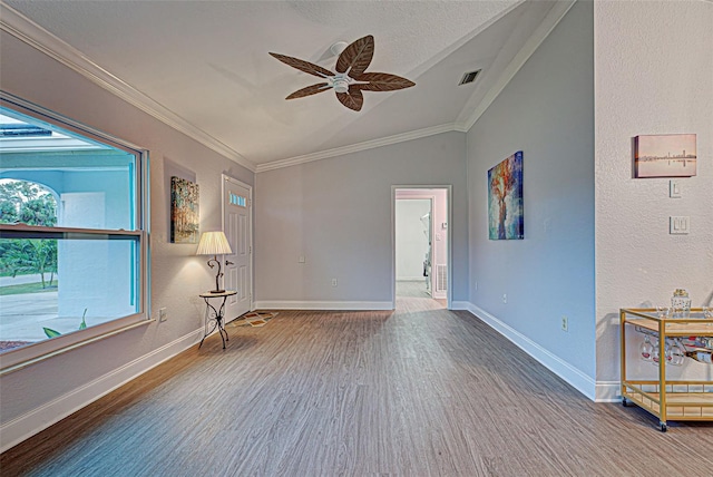 spare room featuring lofted ceiling, ornamental molding, ceiling fan, and hardwood / wood-style flooring