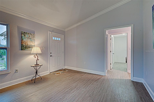 foyer entrance with vaulted ceiling, ornamental molding, and hardwood / wood-style flooring