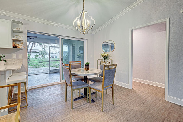 dining space with a chandelier, ornamental molding, and light hardwood / wood-style flooring