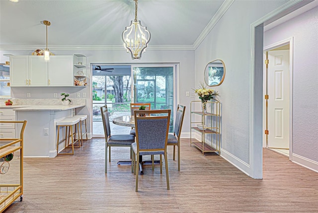 dining area featuring ceiling fan with notable chandelier, light wood-type flooring, and crown molding