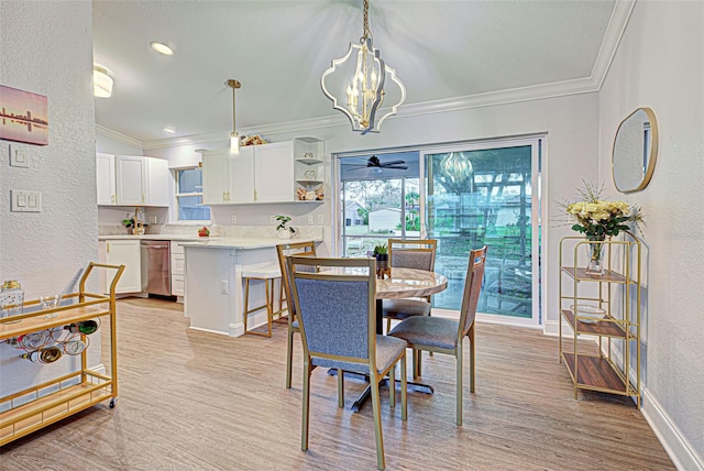 dining space with crown molding, light hardwood / wood-style flooring, and ceiling fan with notable chandelier