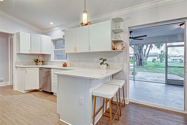 kitchen featuring white cabinets, plenty of natural light, ceiling fan, and a breakfast bar area