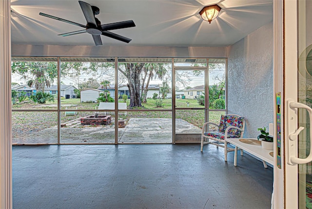 unfurnished sunroom featuring ceiling fan