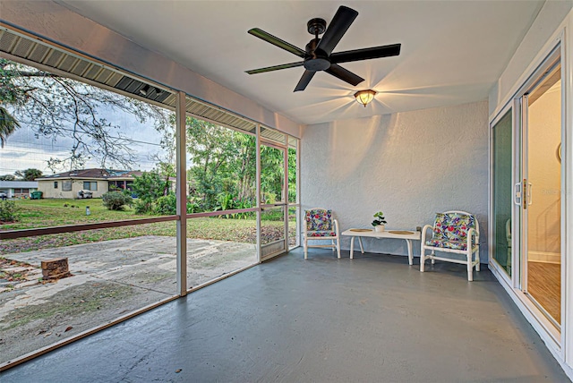 unfurnished sunroom with ceiling fan