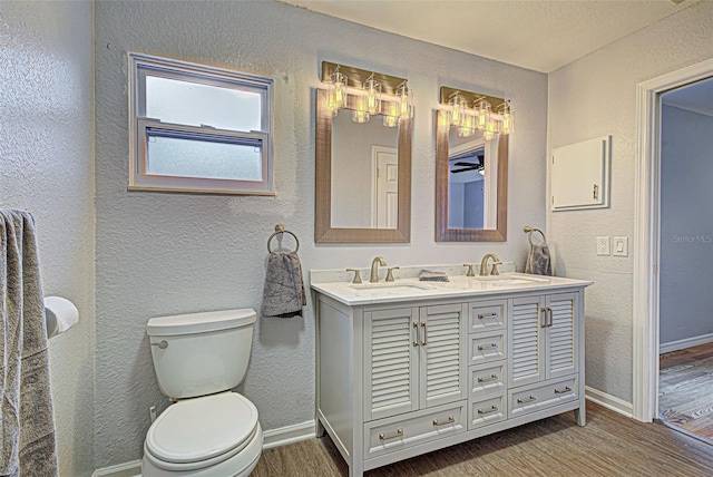 bathroom featuring toilet, dual bowl vanity, and hardwood / wood-style flooring