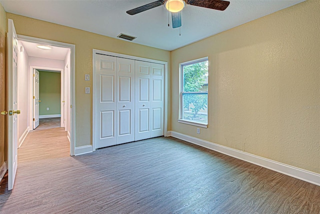 unfurnished bedroom featuring a closet, ceiling fan, and wood-type flooring