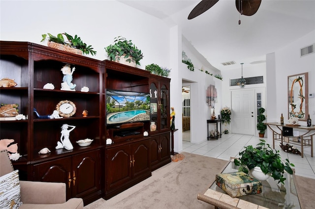 living room with lofted ceiling, ceiling fan, and light colored carpet