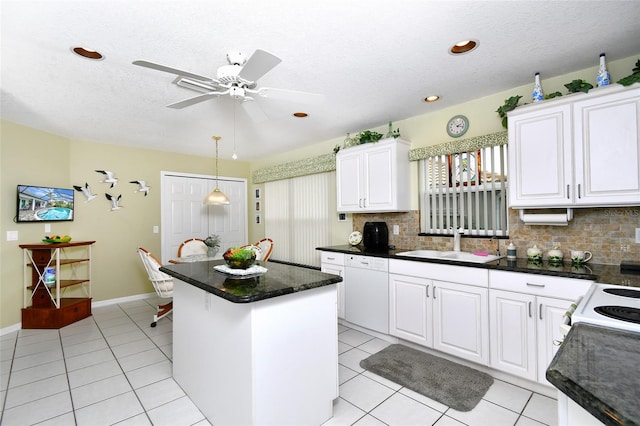 kitchen with pendant lighting, sink, ceiling fan, tasteful backsplash, and a center island