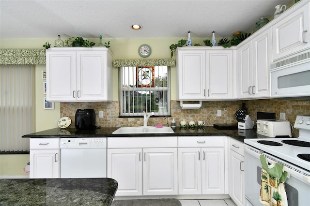 kitchen with tasteful backsplash, white appliances, white cabinetry, and sink