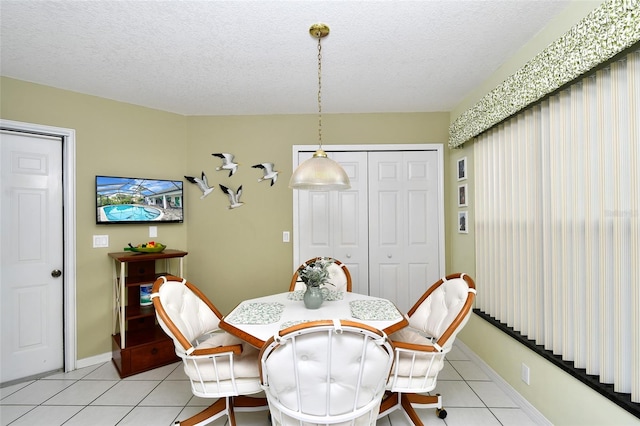 tiled dining space featuring a textured ceiling