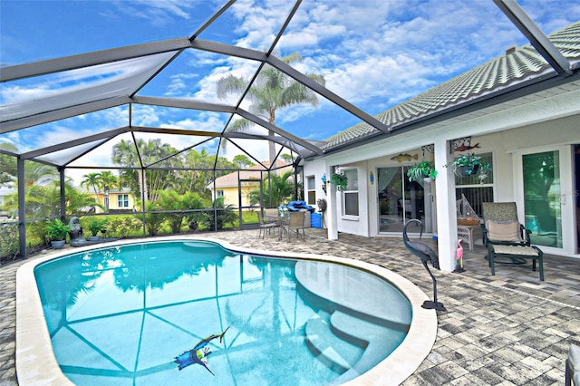 view of pool with glass enclosure and a patio