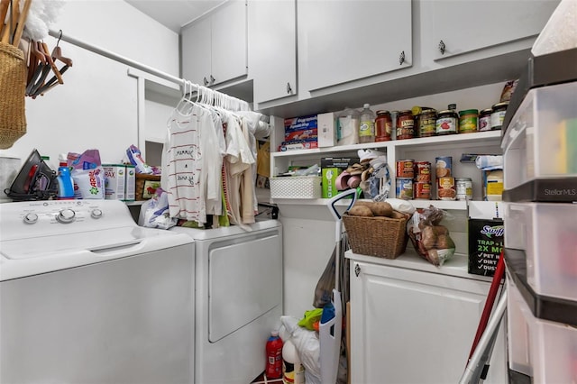 laundry room featuring washing machine and clothes dryer and cabinets