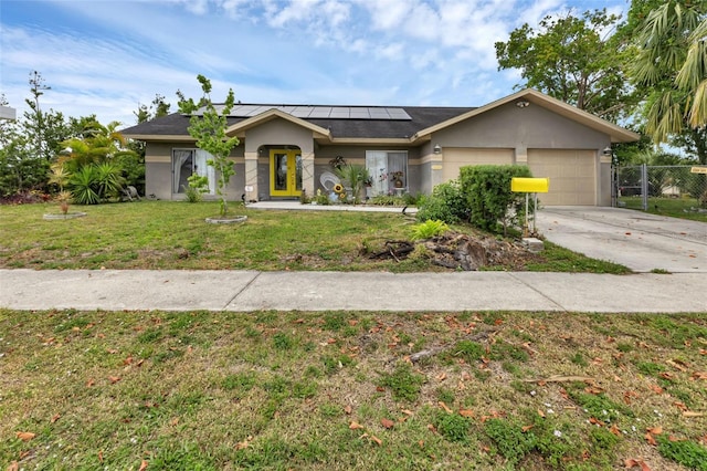 view of front of house with solar panels, a garage, and a front yard