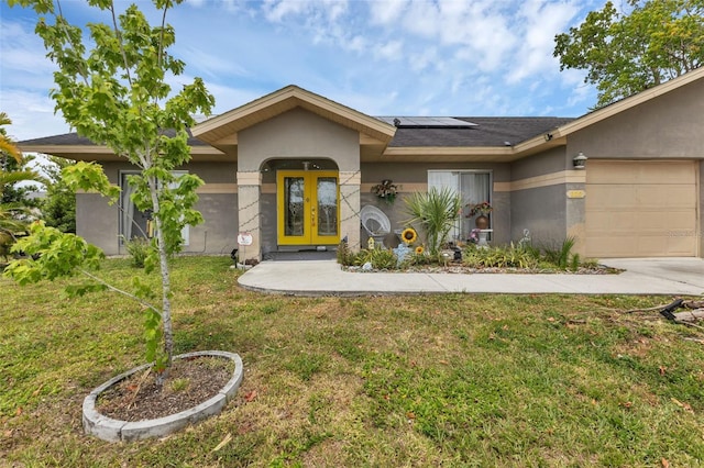 ranch-style house featuring a front lawn, a garage, and solar panels