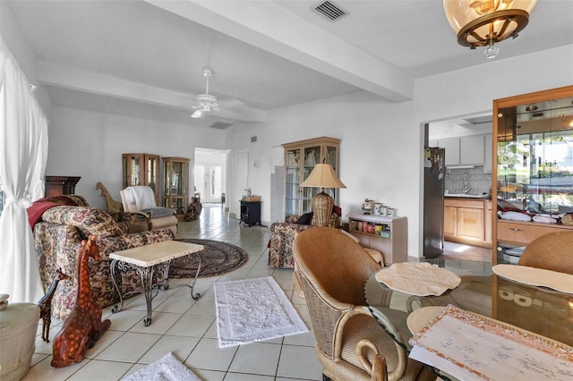 living room with beamed ceiling, ceiling fan, and light tile patterned floors