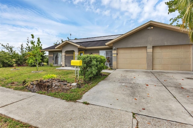 ranch-style home with a front yard, solar panels, and a garage