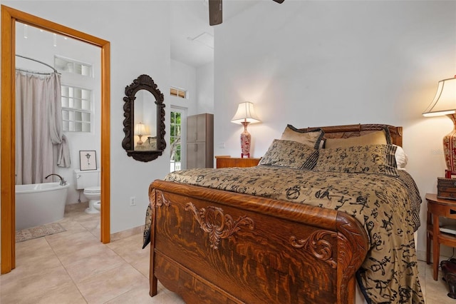 bedroom with ceiling fan, light tile patterned floors, and ensuite bath