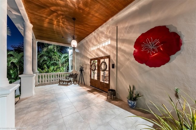 entrance to property featuring covered porch and french doors