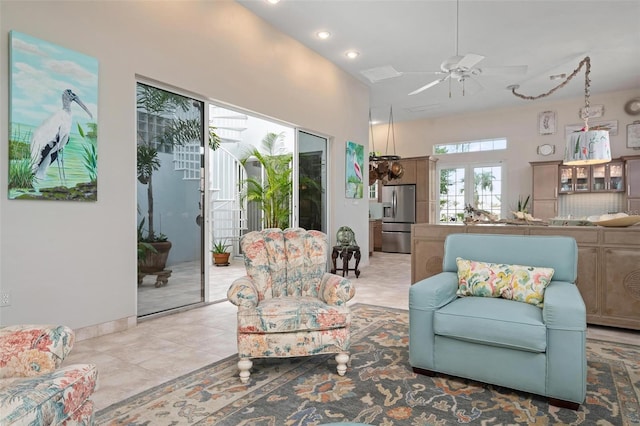 tiled living room with a towering ceiling, ceiling fan, and french doors