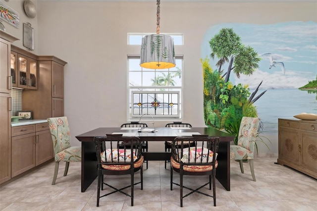 dining room with a towering ceiling and a water view