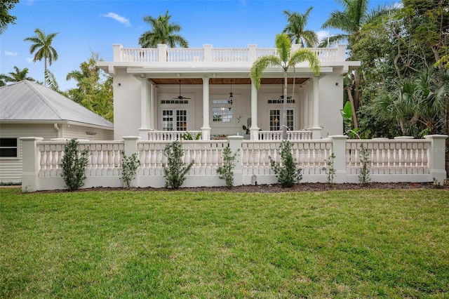 rear view of house featuring french doors and a lawn