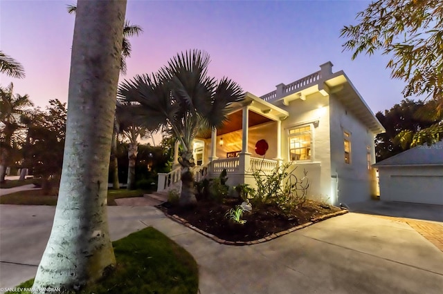 mediterranean / spanish home with a garage, an outdoor structure, and covered porch