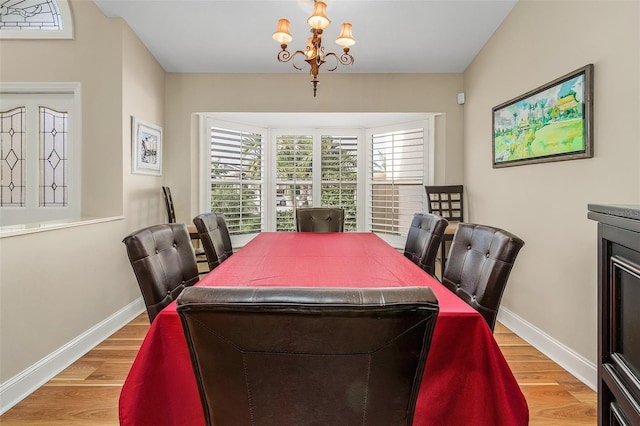 dining space with a chandelier, pool table, and light hardwood / wood-style flooring