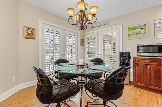 dining room with light hardwood / wood-style floors and a notable chandelier