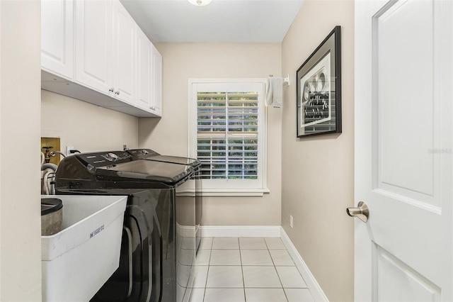 laundry room with separate washer and dryer, light tile floors, and cabinets