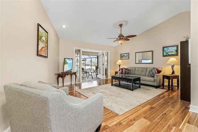 living room with hardwood / wood-style floors, lofted ceiling, and ceiling fan