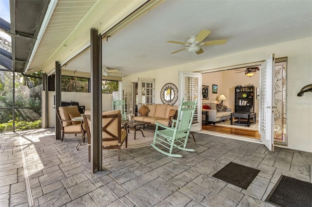 view of terrace featuring an outdoor living space, ceiling fan, and a lanai