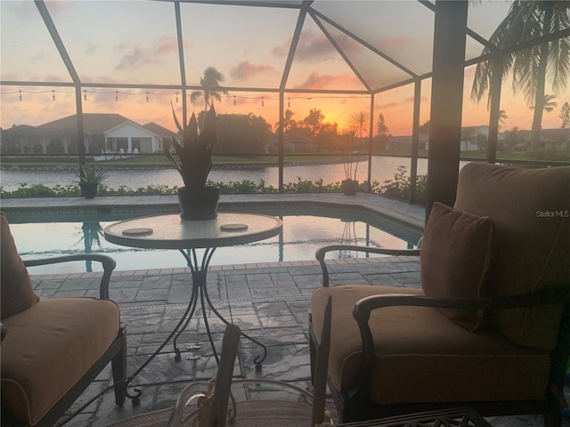 patio terrace at dusk with a water view and a lanai