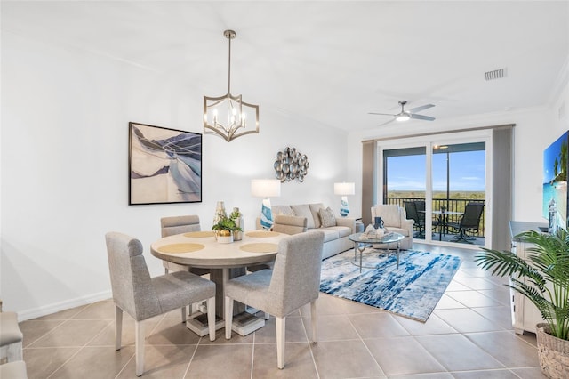 dining room featuring ornamental molding, ceiling fan with notable chandelier, and light tile floors