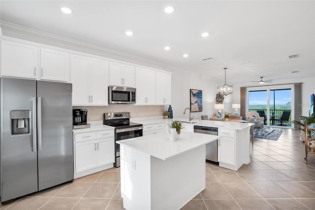 kitchen with stainless steel appliances, decorative light fixtures, kitchen peninsula, ceiling fan with notable chandelier, and tasteful backsplash