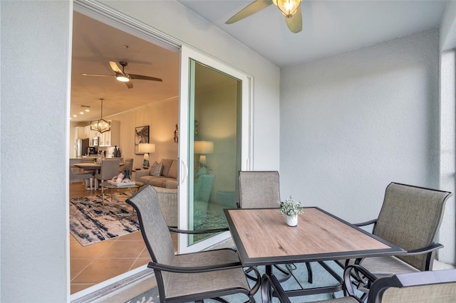 interior space featuring light tile floors and ceiling fan with notable chandelier